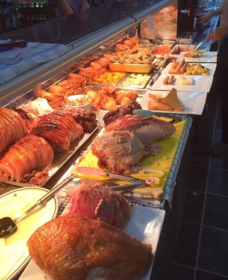 Gammon and turkey being carved at the roast counter, with roast potatoes and pigs in blankets alongside